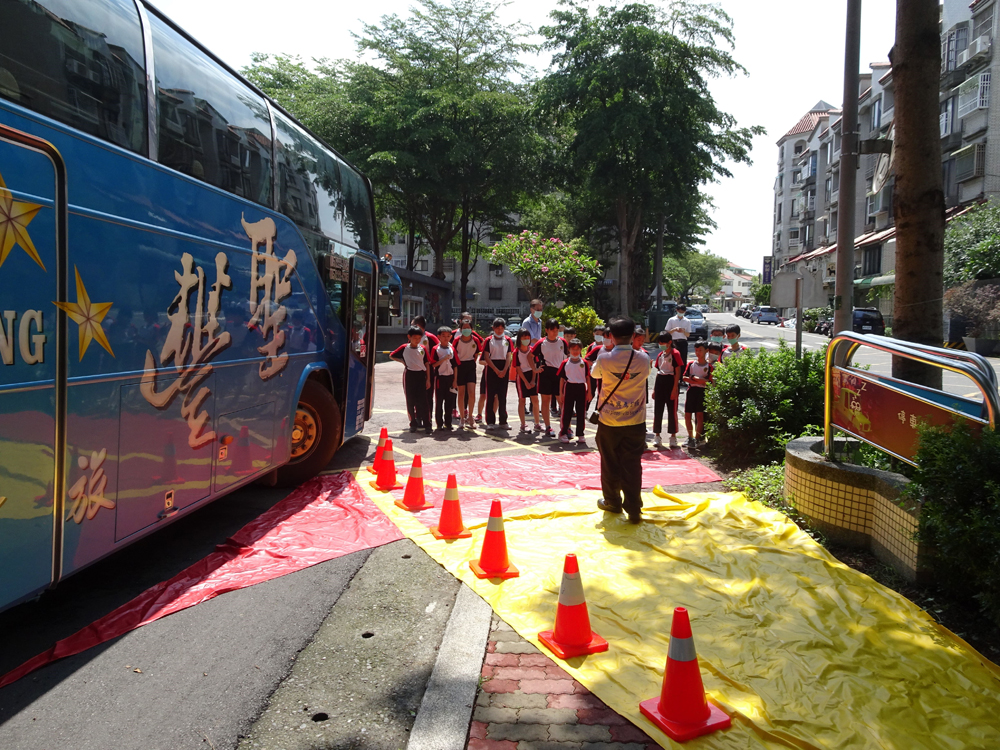 以大客車尺寸量身訂做視野死角(黃色)及內輪差(紅色)帆布，鋪設在大客車四周危險區地上，加深學生對「大型車視野死角及內輪差」的防禦及保持安全距離觀念